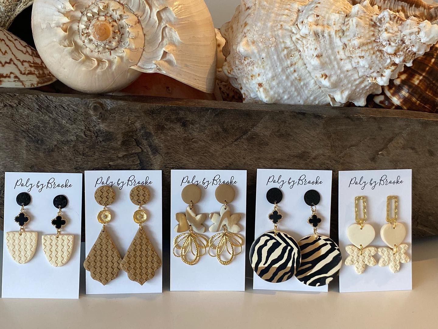 Handmade polymer clay earrings selection by Poly by Brooke in earth coloured tones. Shell decorations in the background