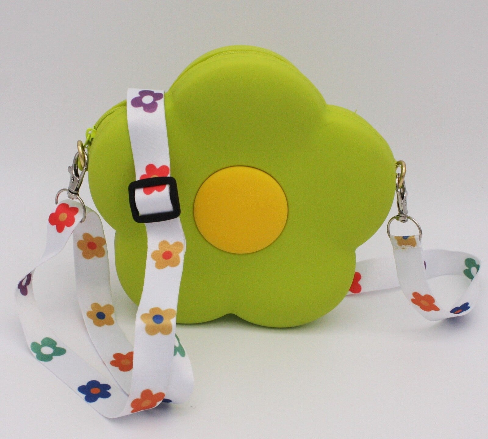 Bright green daisy shaped childrens' bag with colourful daisies on the strap
