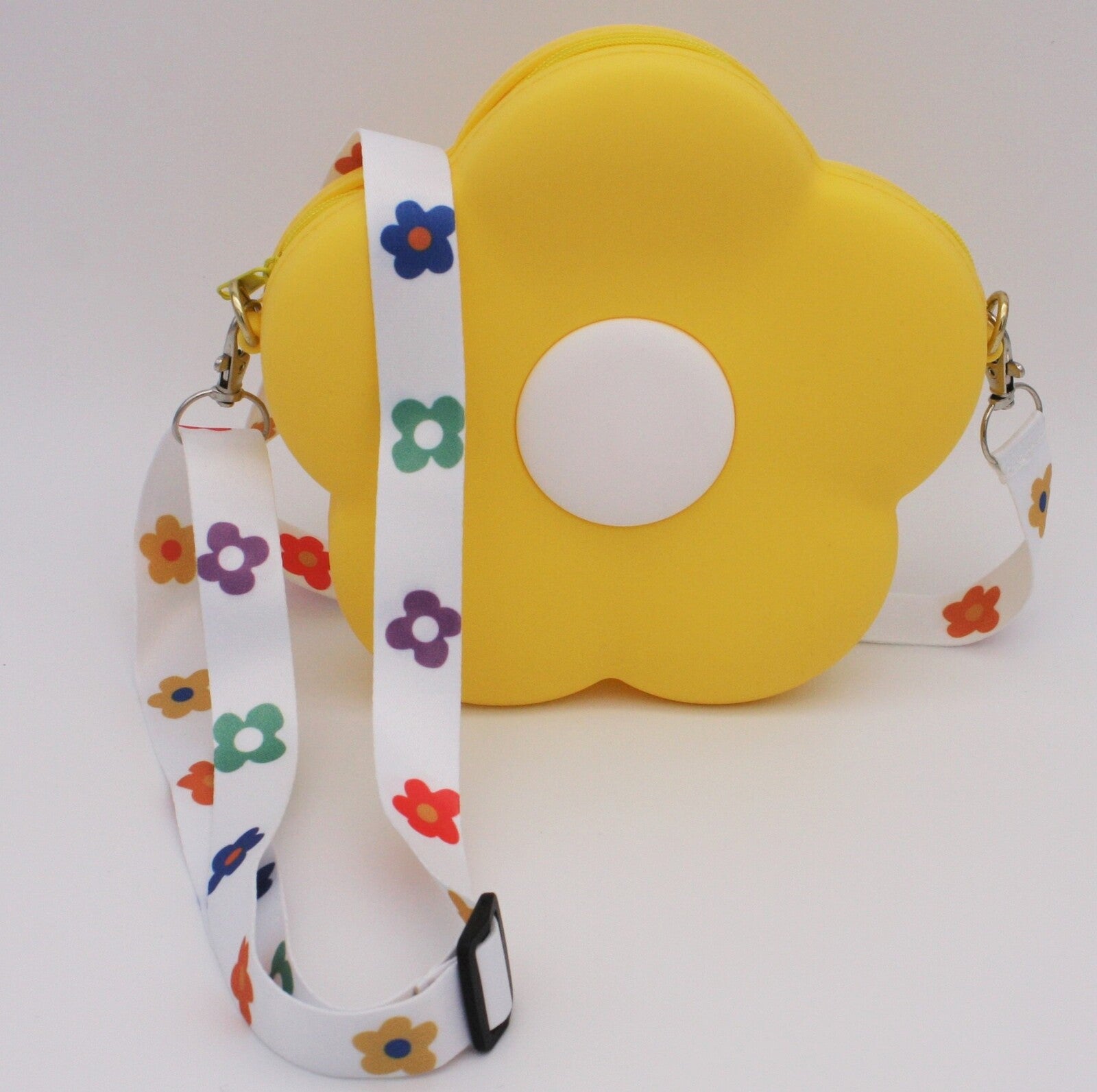 Standing bright yellow daisy bag with colourful daisies on the white strap