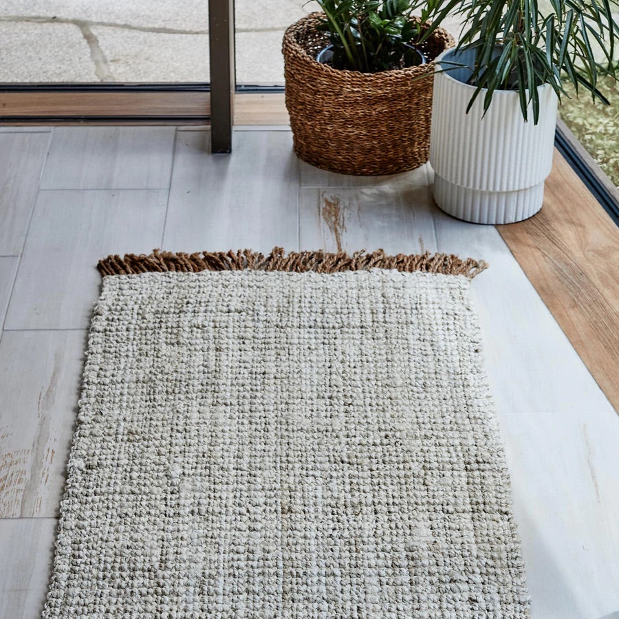 White woven rug with straw coloured fringe detailing