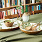 Set table with salad bowls and sage coloured tablecloth