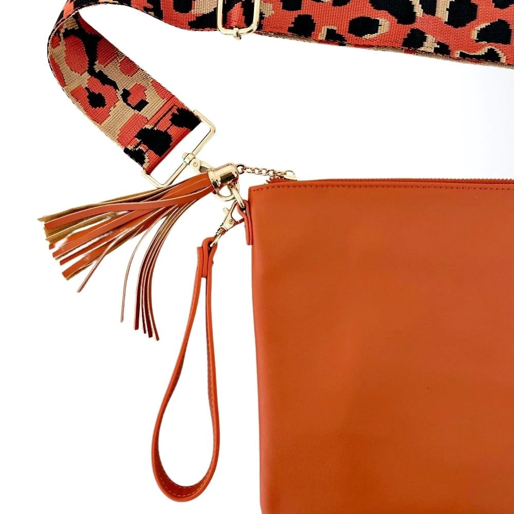 Orange leather bag with orange tassel and leopard print bag strap