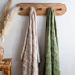 Throws hanging on wooden pegs sage and oatmeal colours