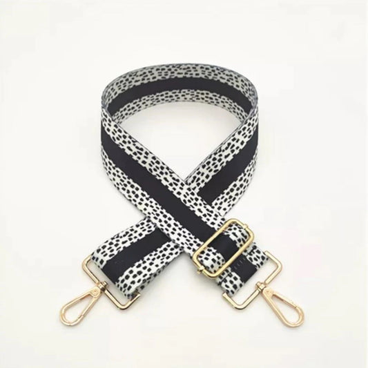 Black and white dotted bag strap with black line through the middle with gold detail