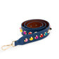 Rolled up blue bag strap with multicoloured studs