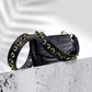 Black vegan leather strap with black and gold studs on a. black croc print leather handbag