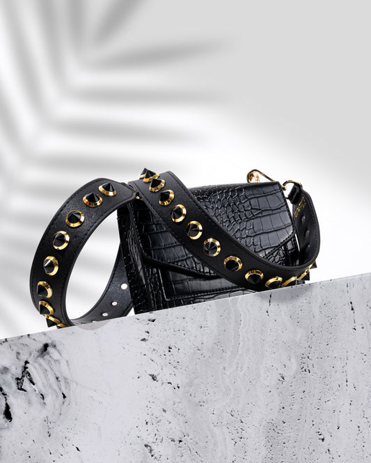 Black vegan leather strap with black and gold studs on a. black croc print leather handbag