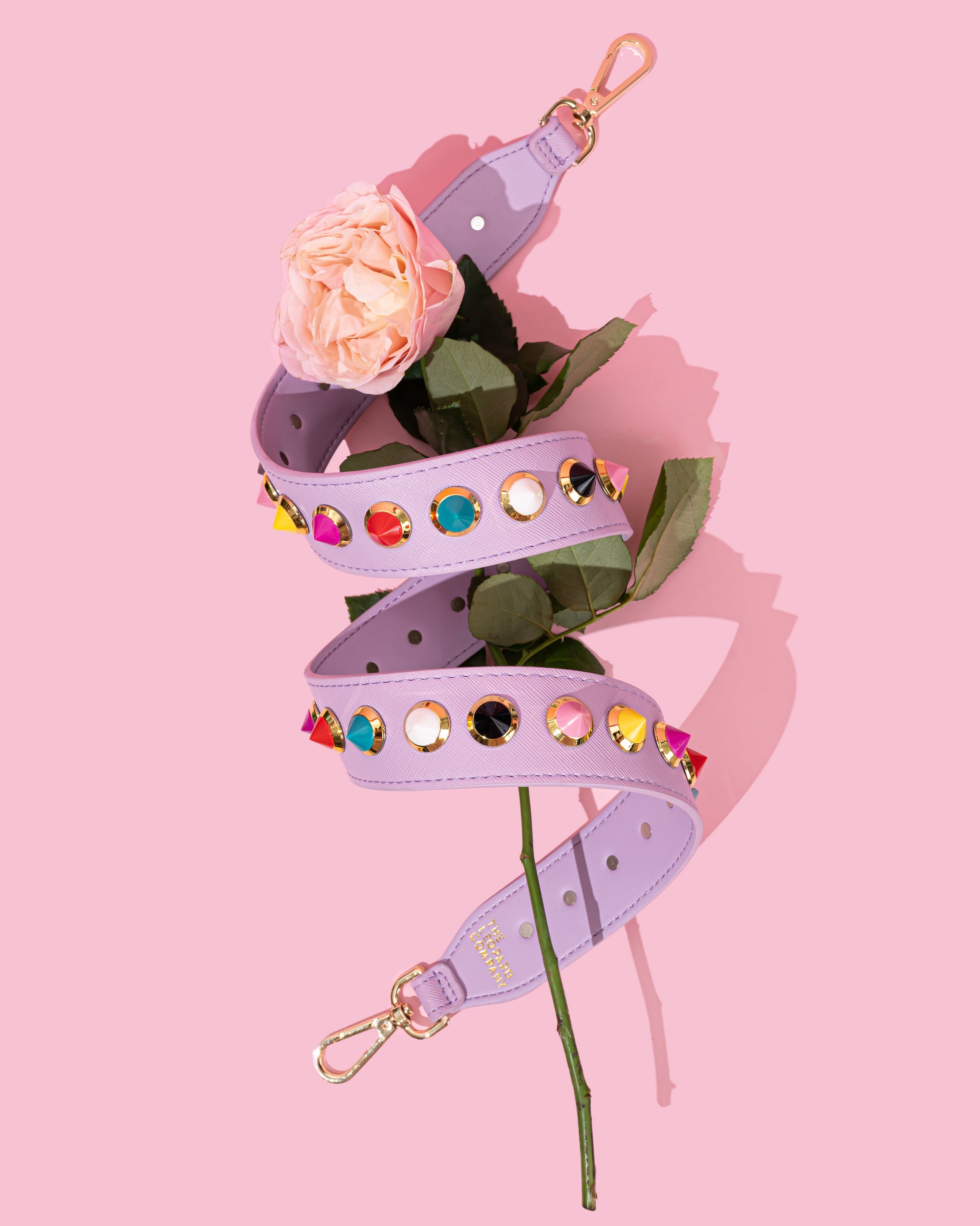 Lilac Bag strap with multi-coloured studs wrapped around a pink rose